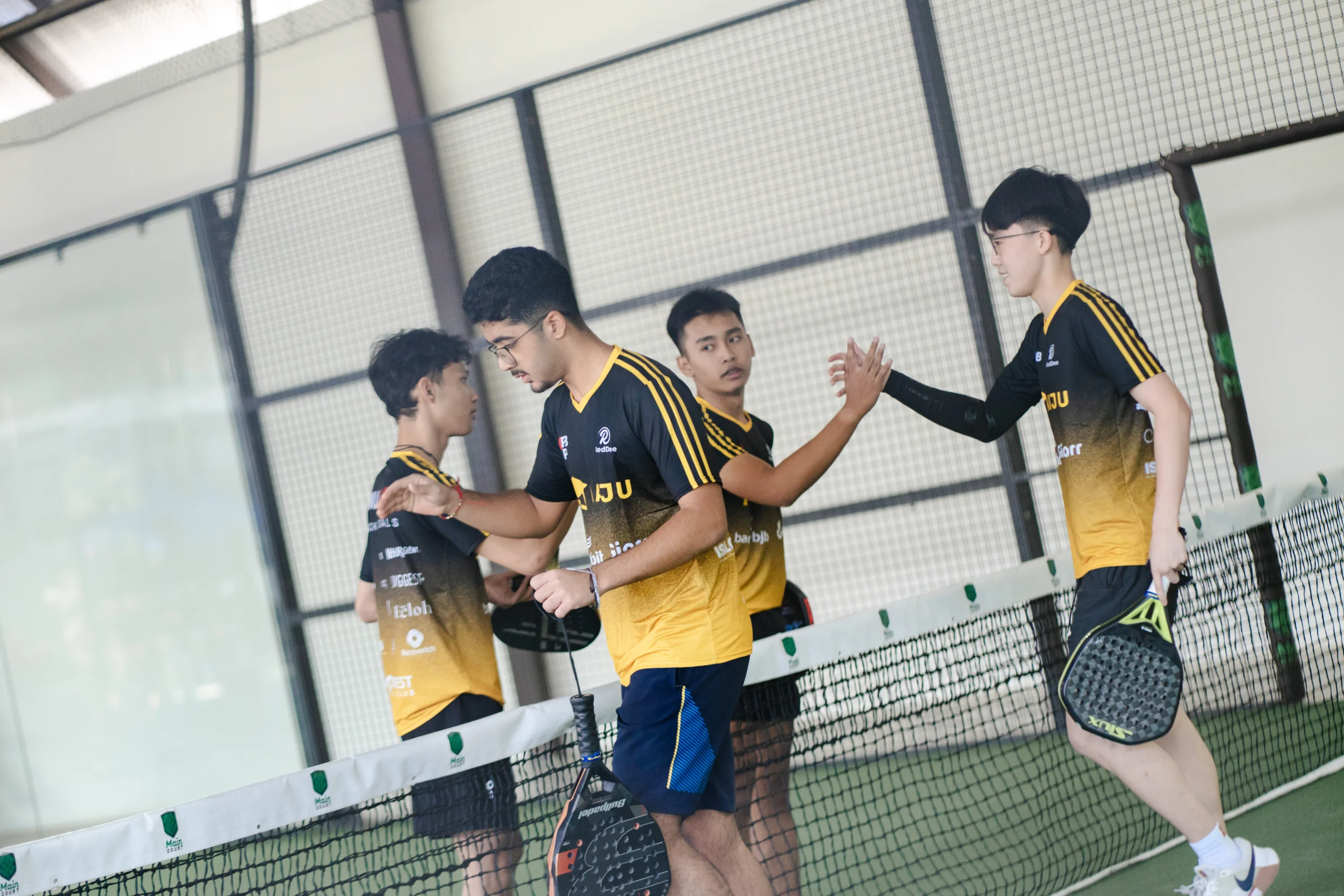 Pasangan bermain padel saling tos